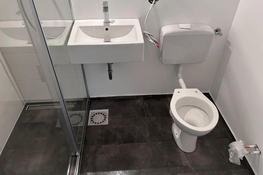 Badsanierung Berlin fertig — modernes Bad mit Dusche, Waschbecken und WC